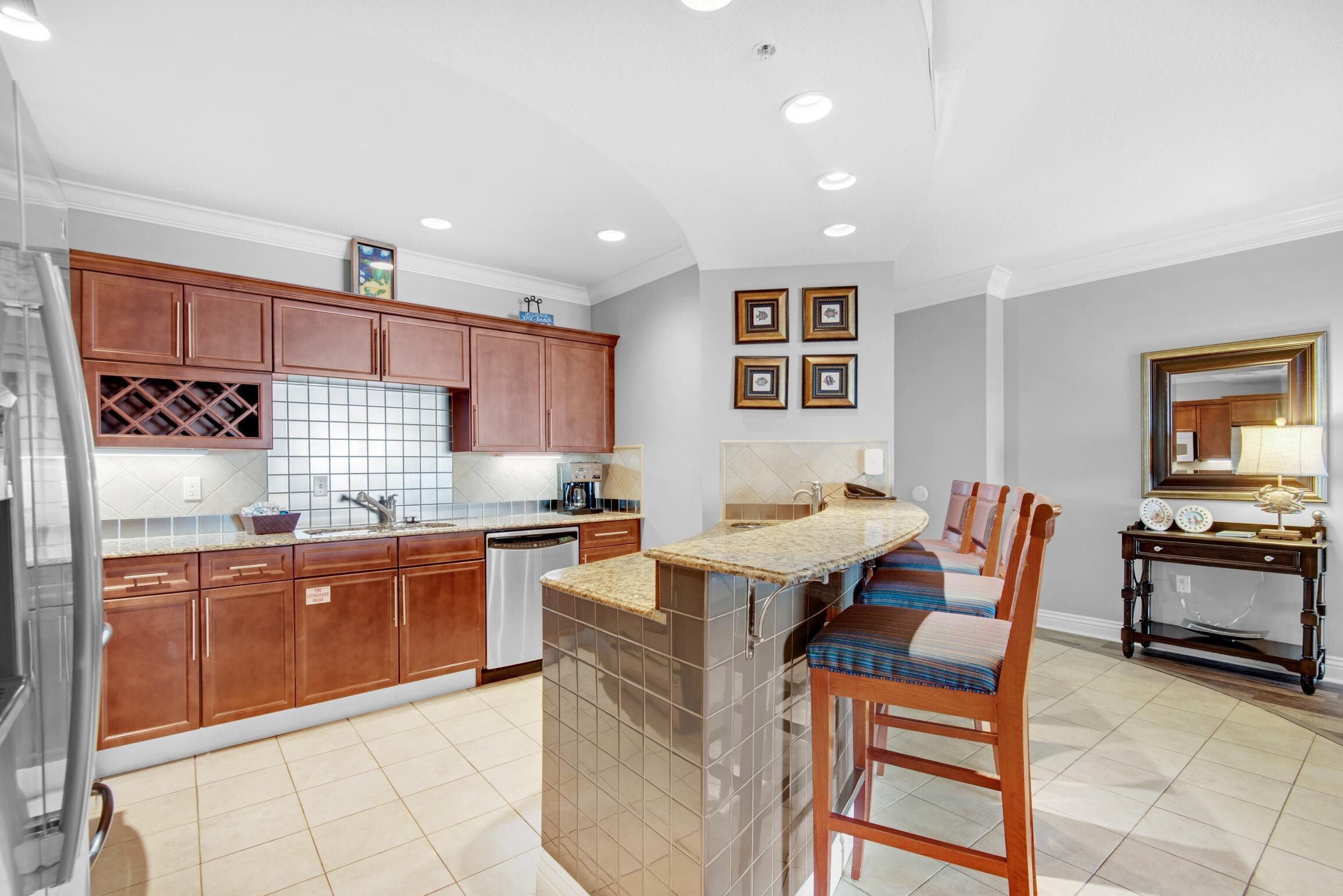 A modern kitchen with wooden cabinets, a built-in island, and a bar area.