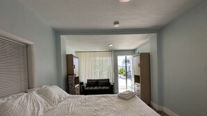 Un dormitorio con una cama grande, un sofá y un armario.