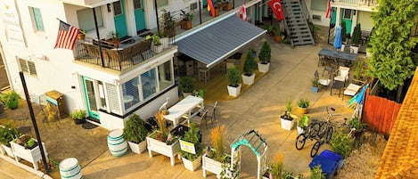 Un hotel con varias terrazas, espacios para sentarse al aire libre y plantas en macetas.