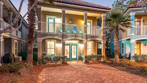 A two-story building with a balcony, a sign indicating a restaurant, and a number '245' on the facade. - Sea Sprite (Destin)