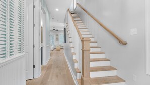 A staircase with wooden steps and a handrail, leading to a landing with a door. - Dock Holiday (Panama City Beach)