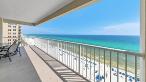 A balcony with a view of a beach and ocean.