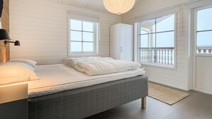 Une chambre à coucher avec un lit, une fenêtre, une armoire et une lampe suspendue.
