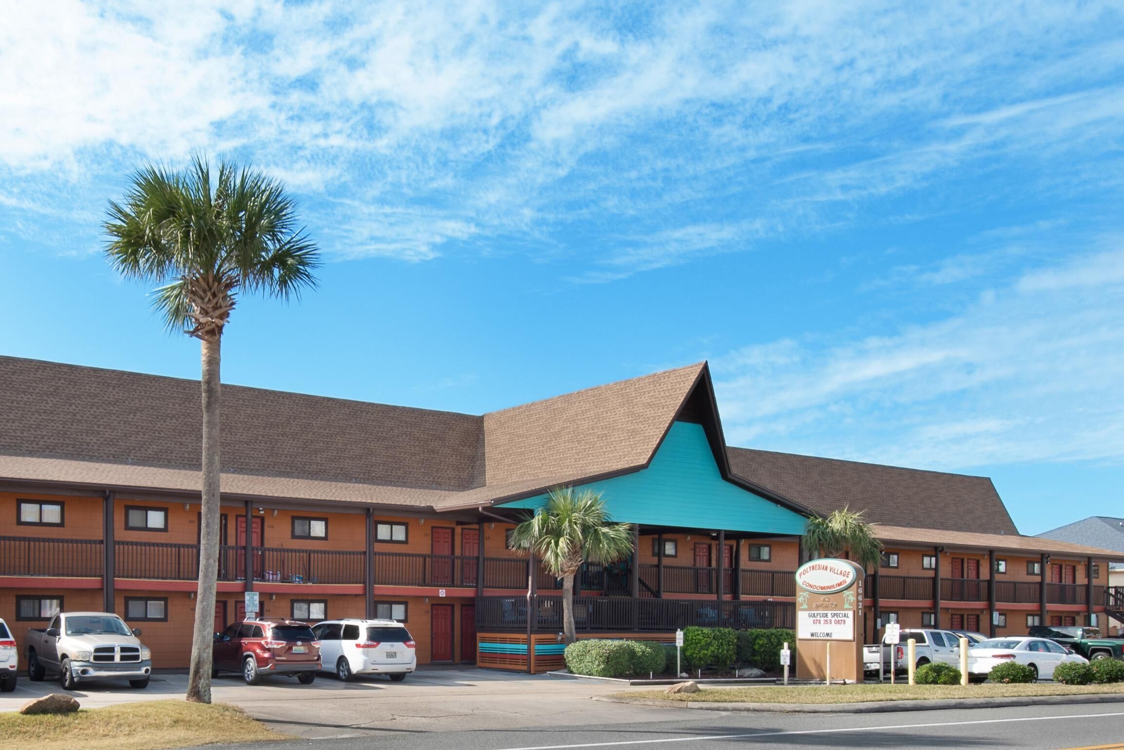 A motel with a brown exterior, a green awning, and a sign that reads "Motel."