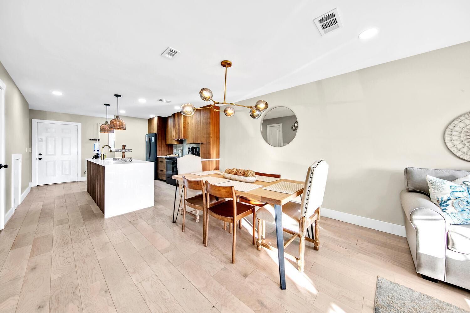 Cocina moderna con armarios de madera, una isla central e iluminación colgante.