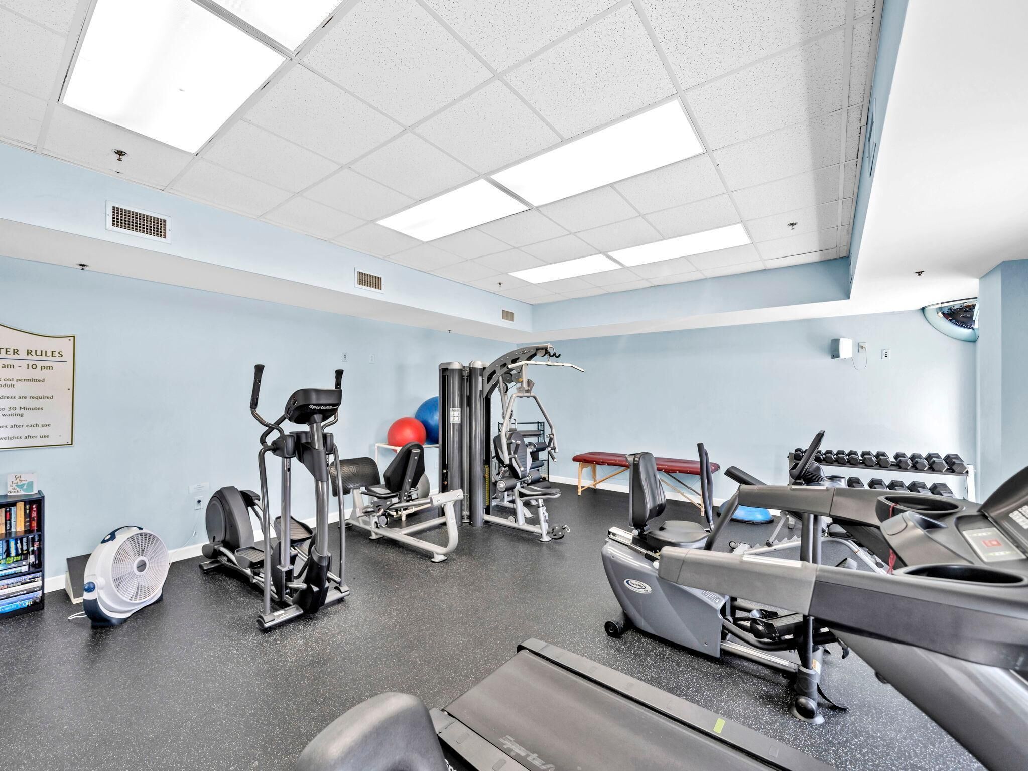 Et fitnesscenter med løbebånd, crosstrainere og vægte.
