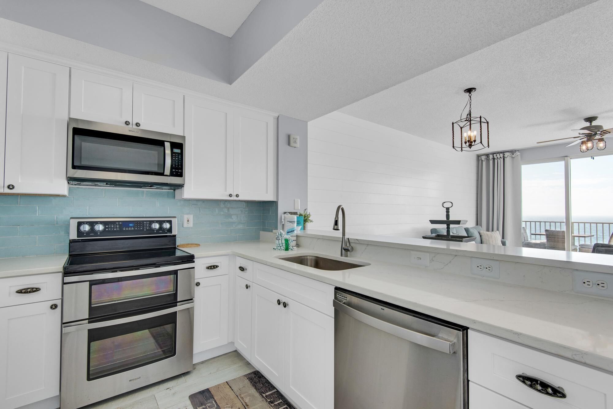 A modern kitchen with white cabinetry, a built-in microwave, a stove, and a dishwasher.