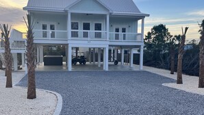 A two-story white house with a covered porch, a driveway, and a number '145' on the front.