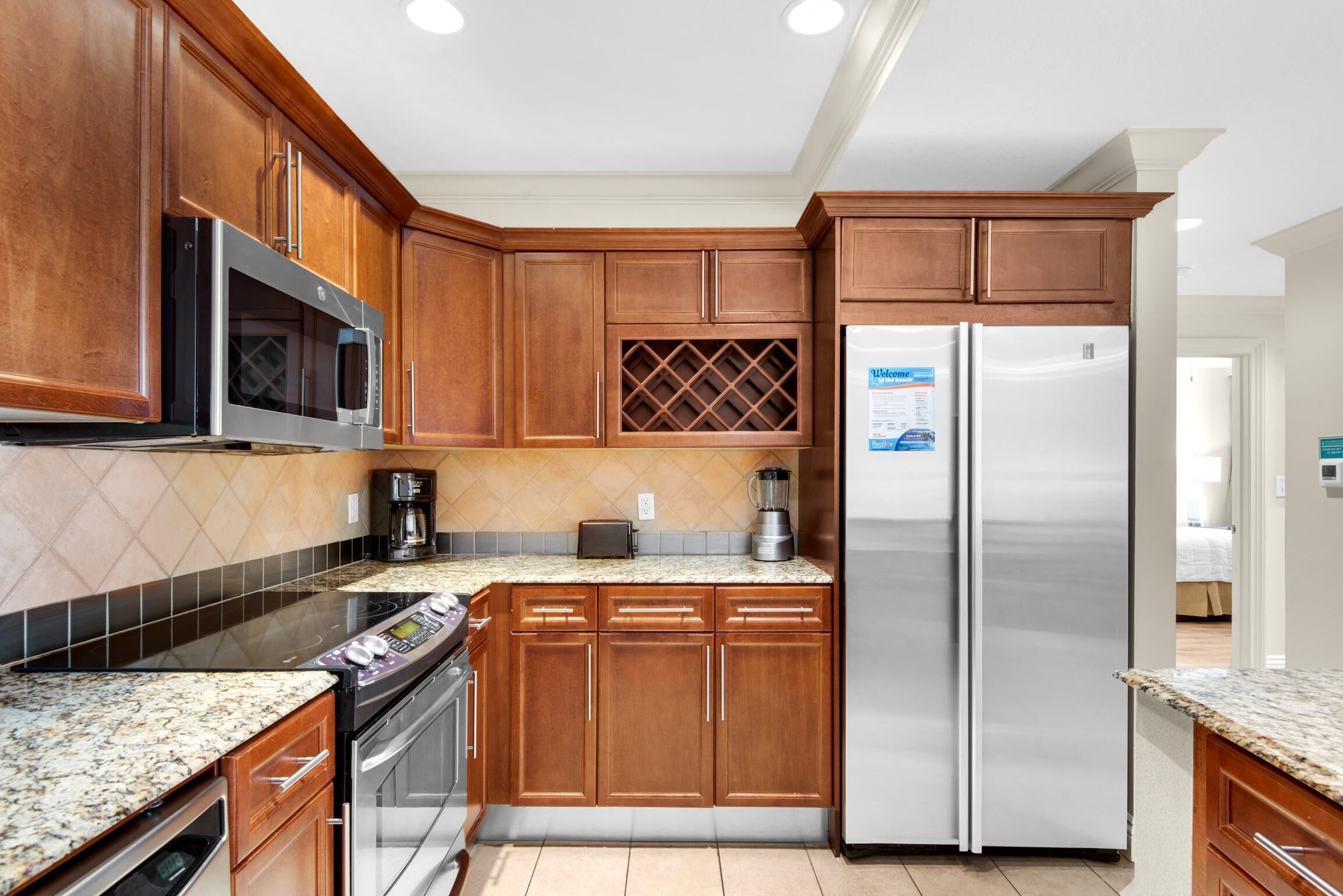 A kitchen with wooden cabinets, stainless steel appliances, and a granite countertop.
