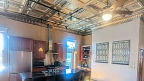 Una cocina moderna con una isla central, electrodomésticos de acero inoxidable y un techo decorativo.