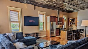 Una sala de estar moderna con un sofá modular, una mesa de centro y un televisor montado en la pared.
