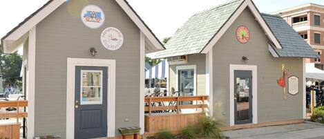 Two small, single-story buildings with a simple, functional design, each featuring a door and a small porch area.