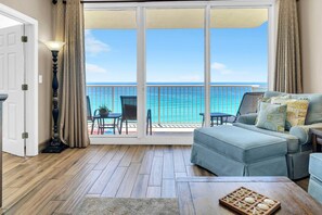 A room with a view of the ocean, a sofa, a table, and a lamp. - Majestic Beach Towers 2-901 (Panama City Beach)