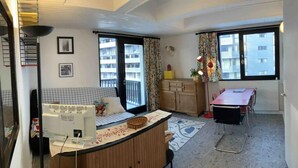 A compact living space with a kitchenette, a dining area, and a sofa.