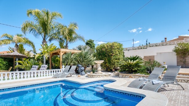 A swimming pool with a sunken design, surrounded by lounge chairs and palm trees. - Apartment 'Carpe Diem' with Shared Pool, Wi-Fi and Air Conditioning (Alicante (Alacant))
