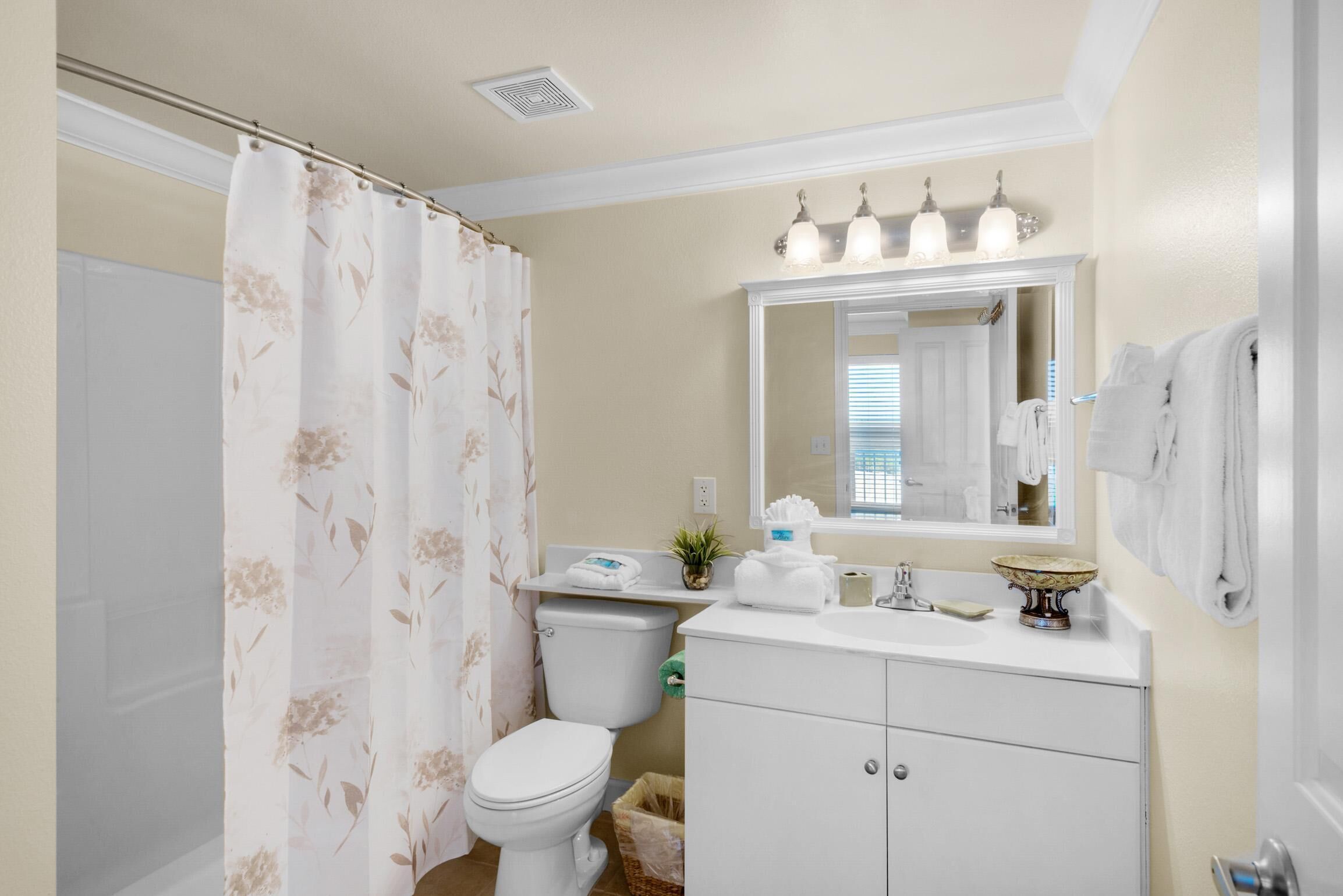 A bathroom with a toilet, sink, and mirror.