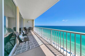 A balcony with a view of the ocean, furnished with chairs and a table. - Majestic Beach Towers I 2002 Stay Salty (Panama City Beach)