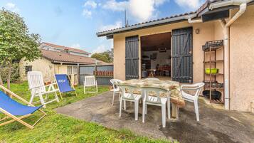 Una casa con patio, tavolo e sedie.