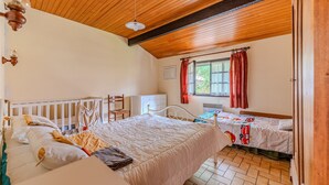 A bedroom with two beds, wooden ceiling beams, a window with red curtains, and a white dresser. - Holiday Home 'Blanche Neige Mimizan' with Private Terrace and Shared Garden (Mimizan)