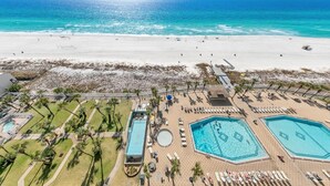 Un complexe hôtelier de bord de mer doté de plusieurs piscines, d’une plage et offrant une vue sur l’océan.