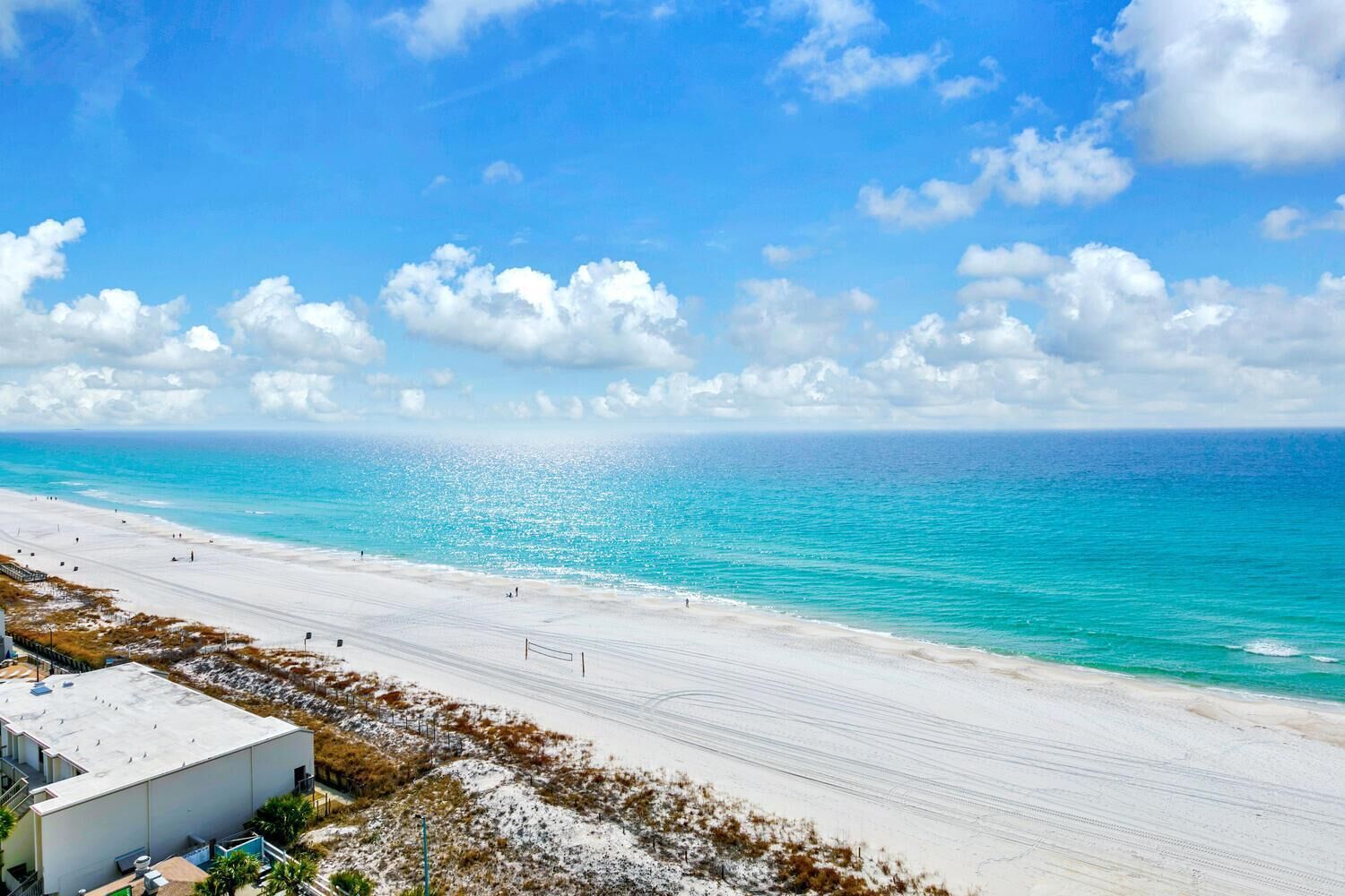 Une plage avec un ciel dégagé et une mer calme.