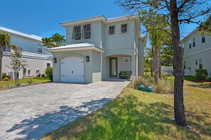 Uma casa de dois andares com garagem frontal, cobertura de entrada e um pequeno alpendre.