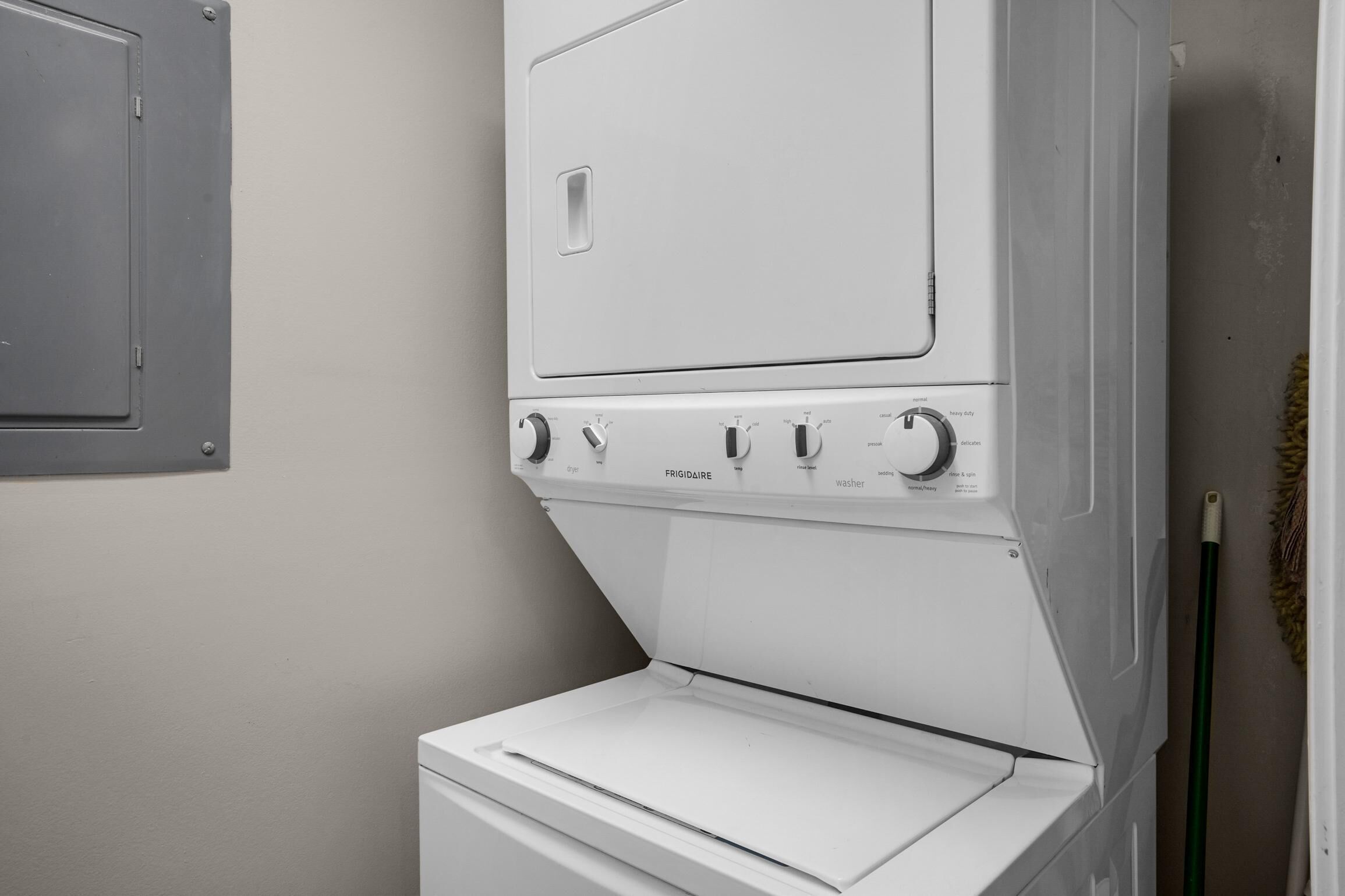 A front-loading white washer and dryer unit with control knobs and a front panel.