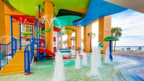A water park with slides, a pool, and a beach area with lounge chairs. - Splash 603e (Panama City Beach)