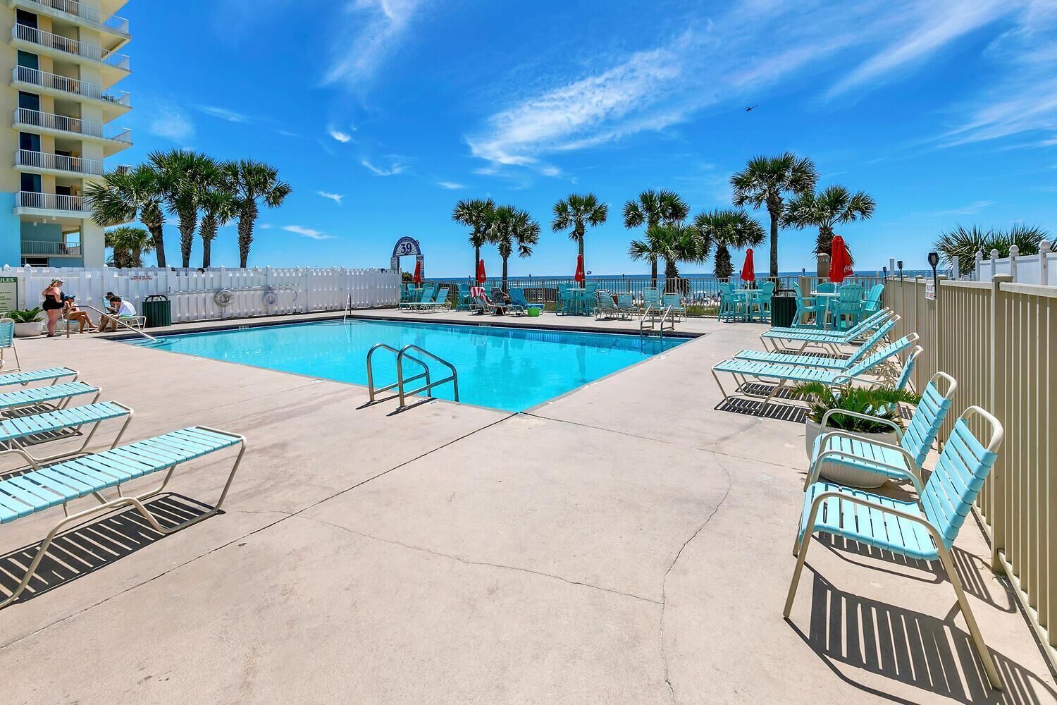 A pool area with lounge chairs and a sign indicating the pool's number.