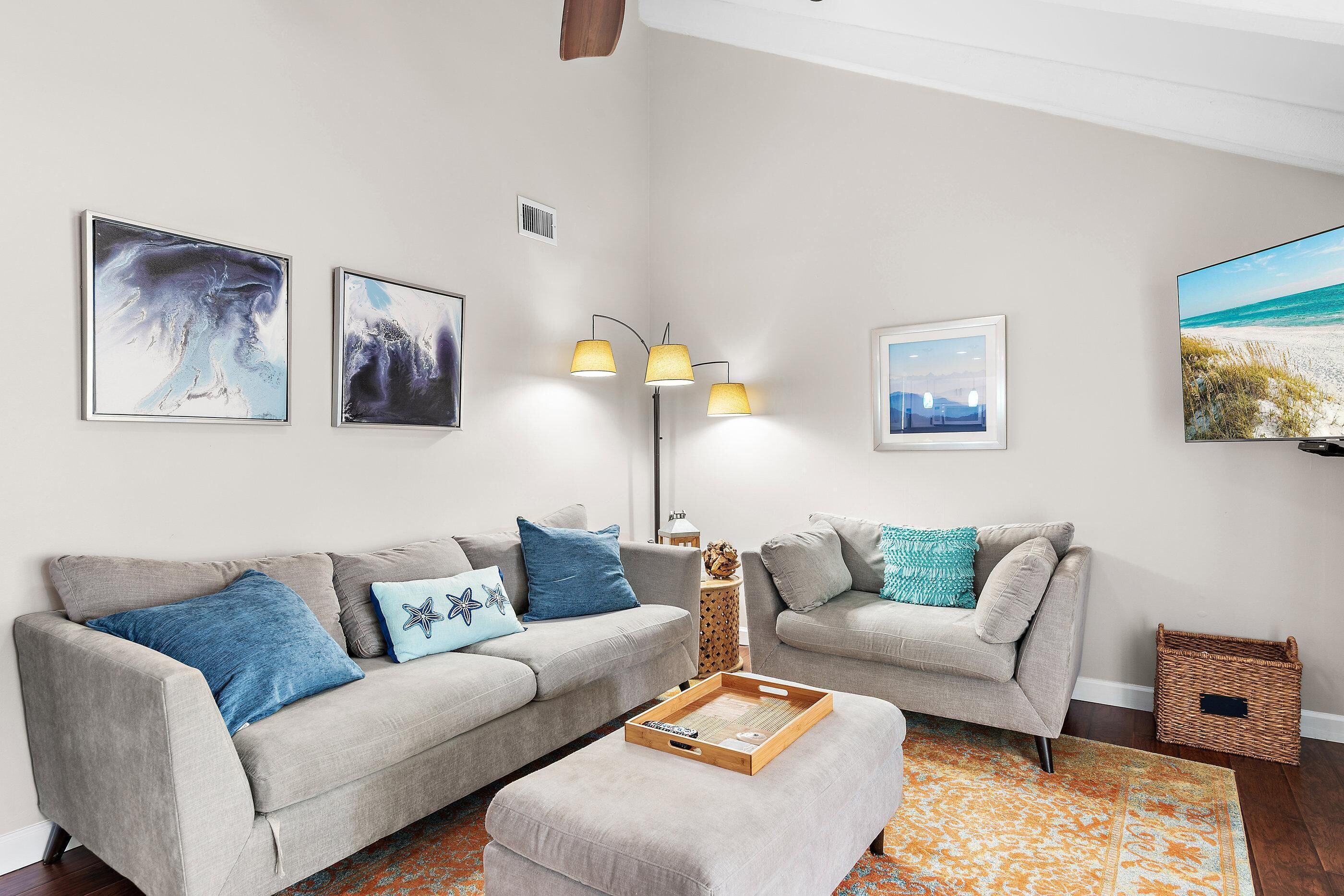A living room with two grey sofas, a wooden coffee table, and a floor lamp.