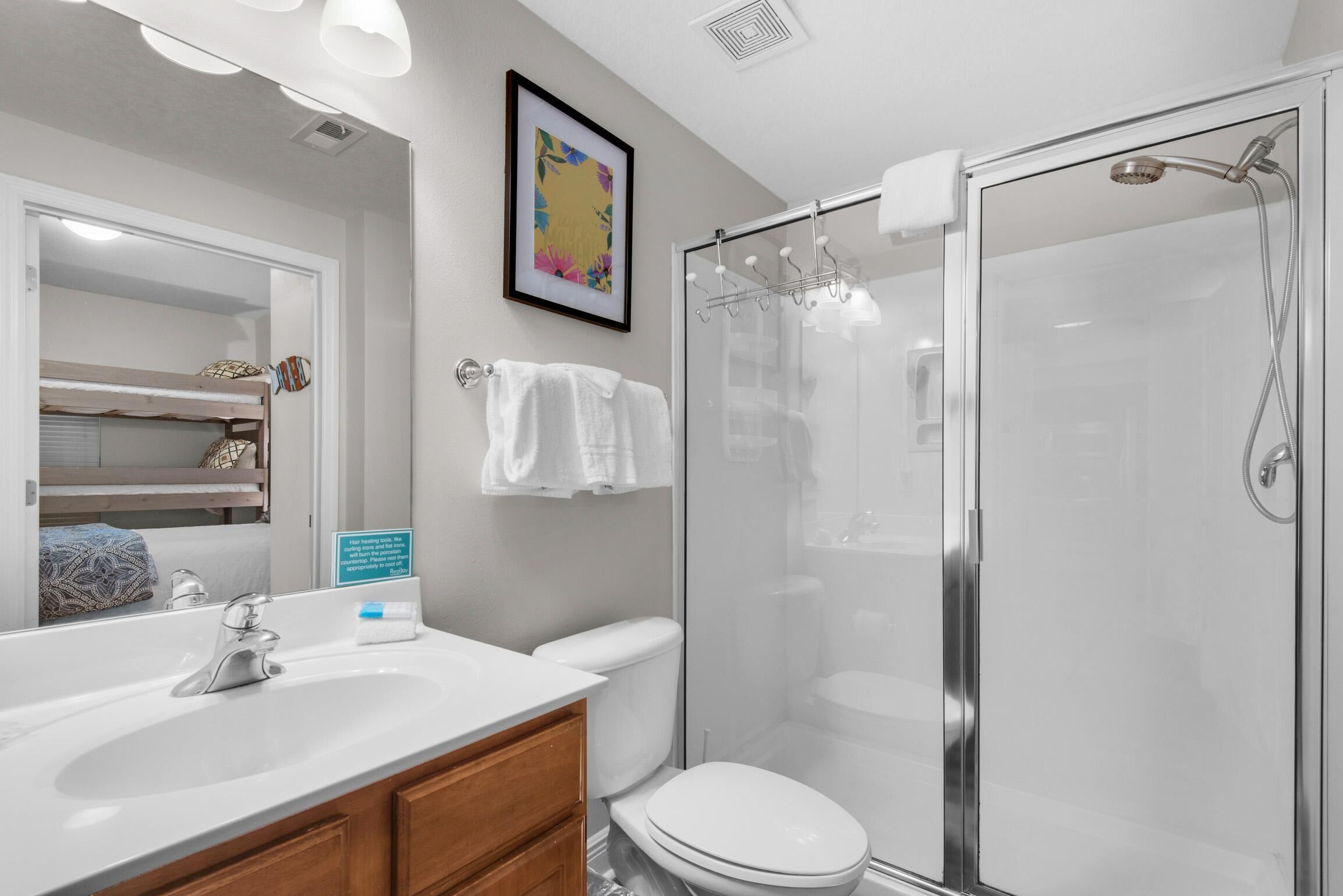 Une salle de bain moderne avec une douche à parois de verre, un lavabo blanc et des toilettes.