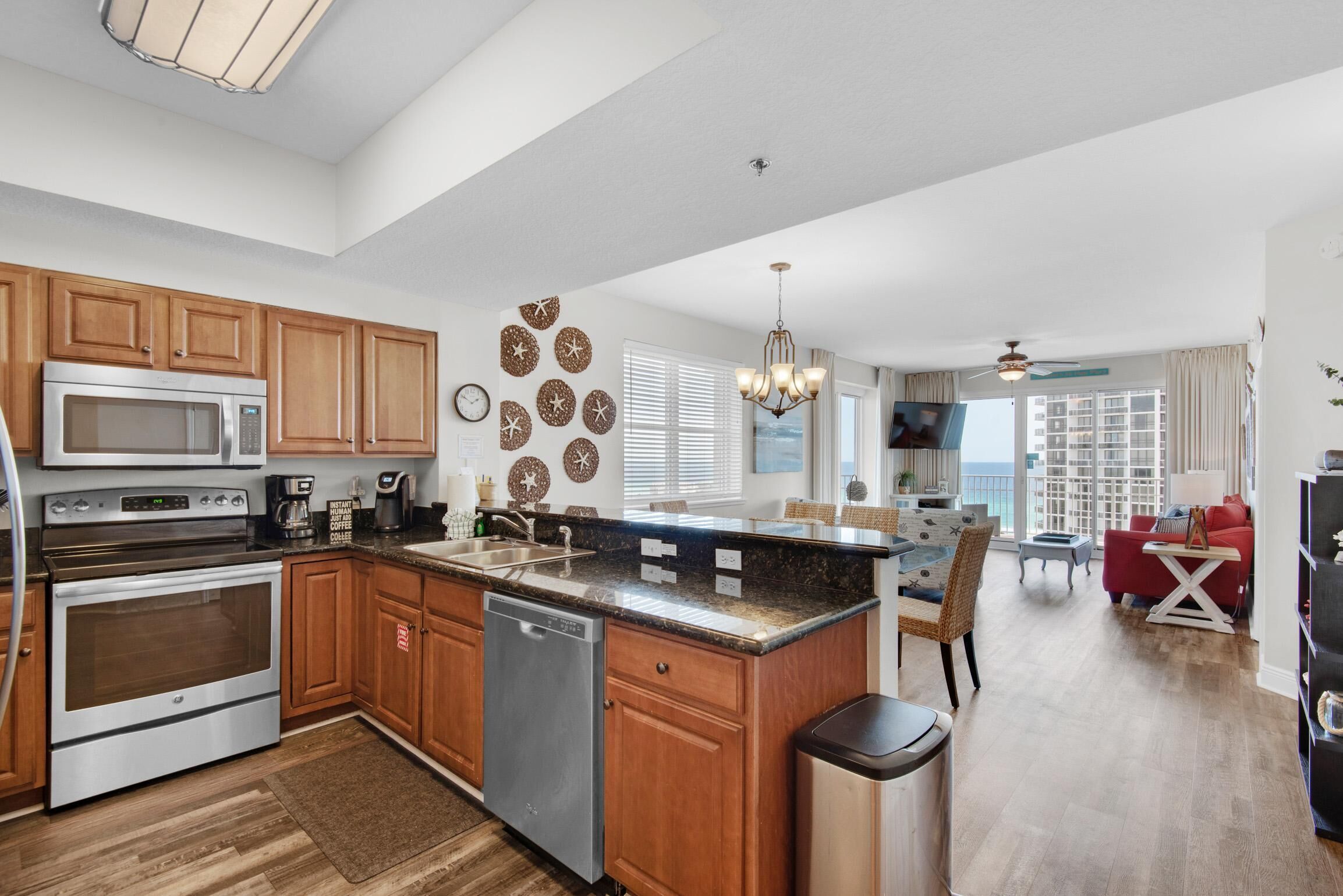 A modern kitchen with wooden cabinets, stainless steel appliances, and a central island.