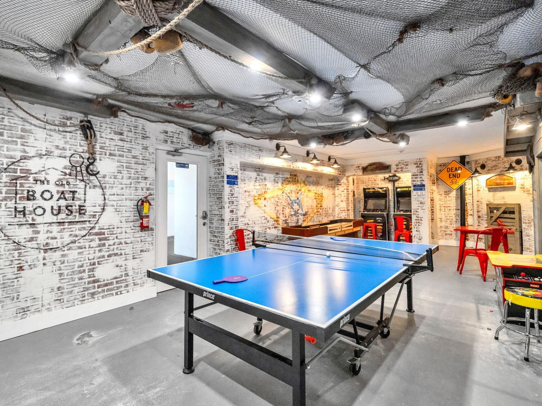 A room with a ping pong table, a brick wall with graffiti, and a 'DEAD END' sign.