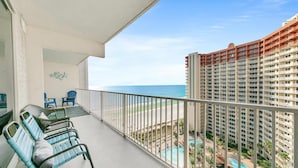 A balcony with outdoor seating, a view of the ocean, and a pool area. - Shores of Panama 1523 (Panama City Beach)