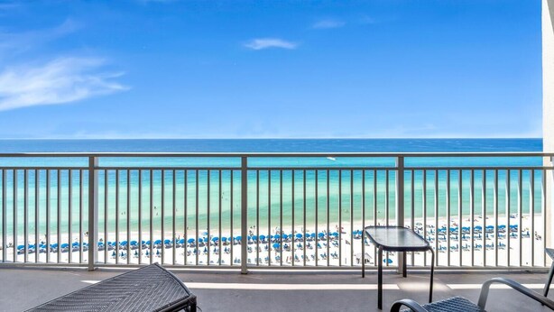 Un balcon avec vue sur une plage et l’océan.