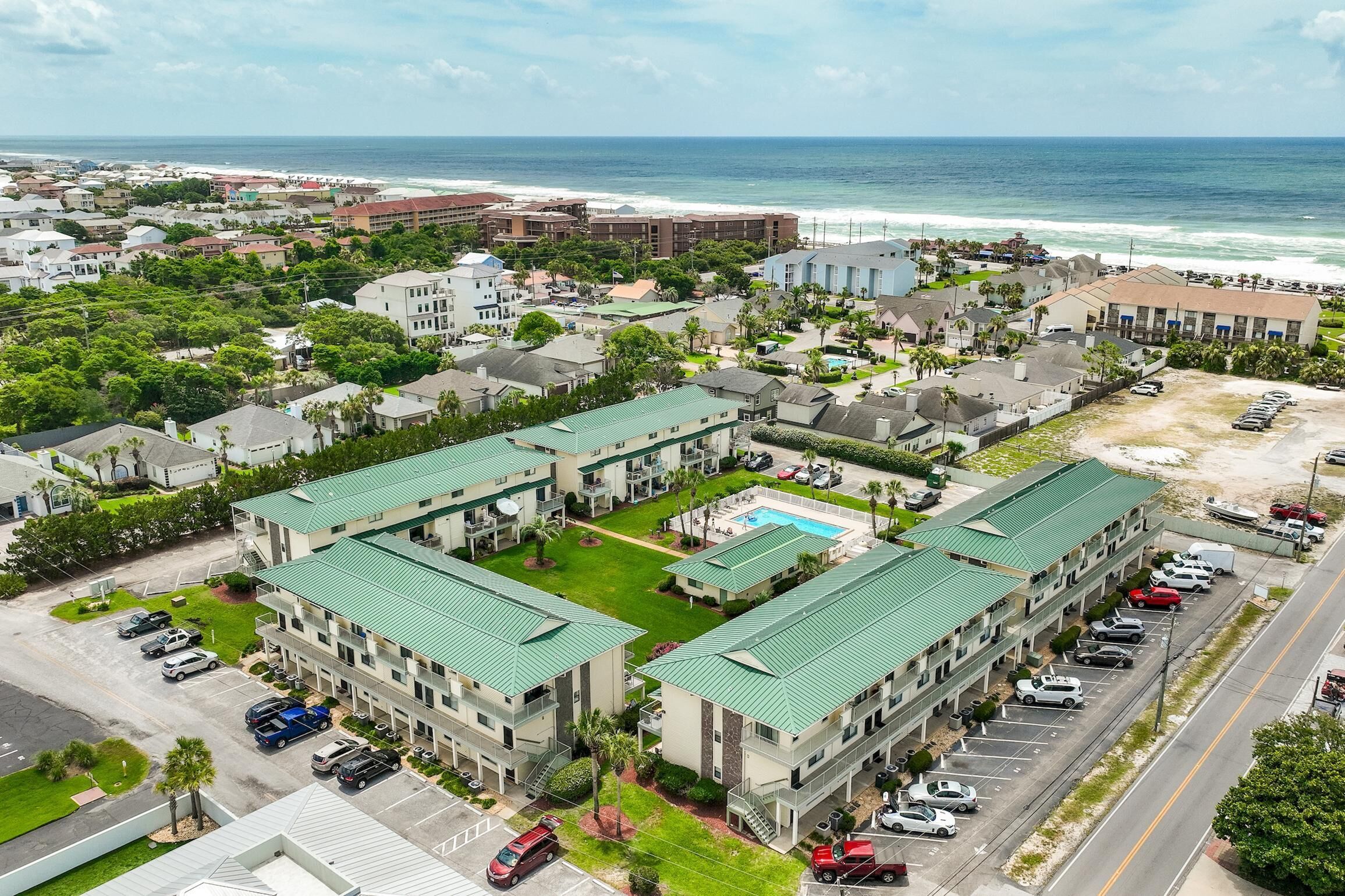 A hotel with multiple buildings, a swimming pool, and a parking lot.