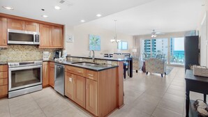 A modern kitchen with wooden cabinets, stainless steel appliances, and a large island. - Sterling Shores 402 (Destin)