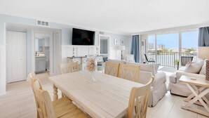 Una sala de estar moderna con comedor, cocina y un balcón con vistas a la ciudad.