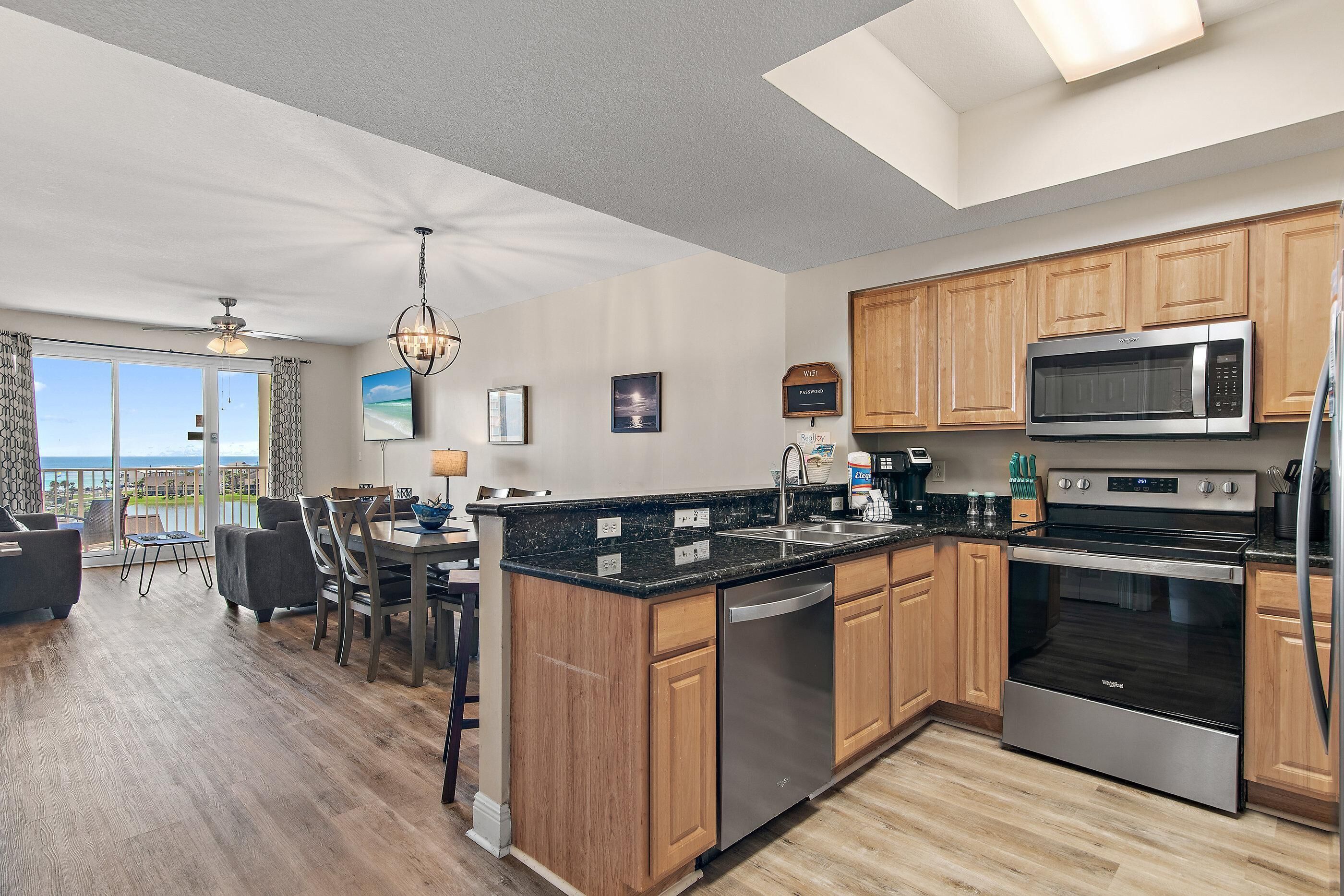 A modern kitchen with wooden cabinets, a built-in microwave, and stainless steel appliances.
