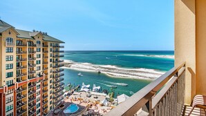 A high-rise hotel with multiple balconies overlooking a beach and ocean. - Emerald Grande W1221 (Destin)