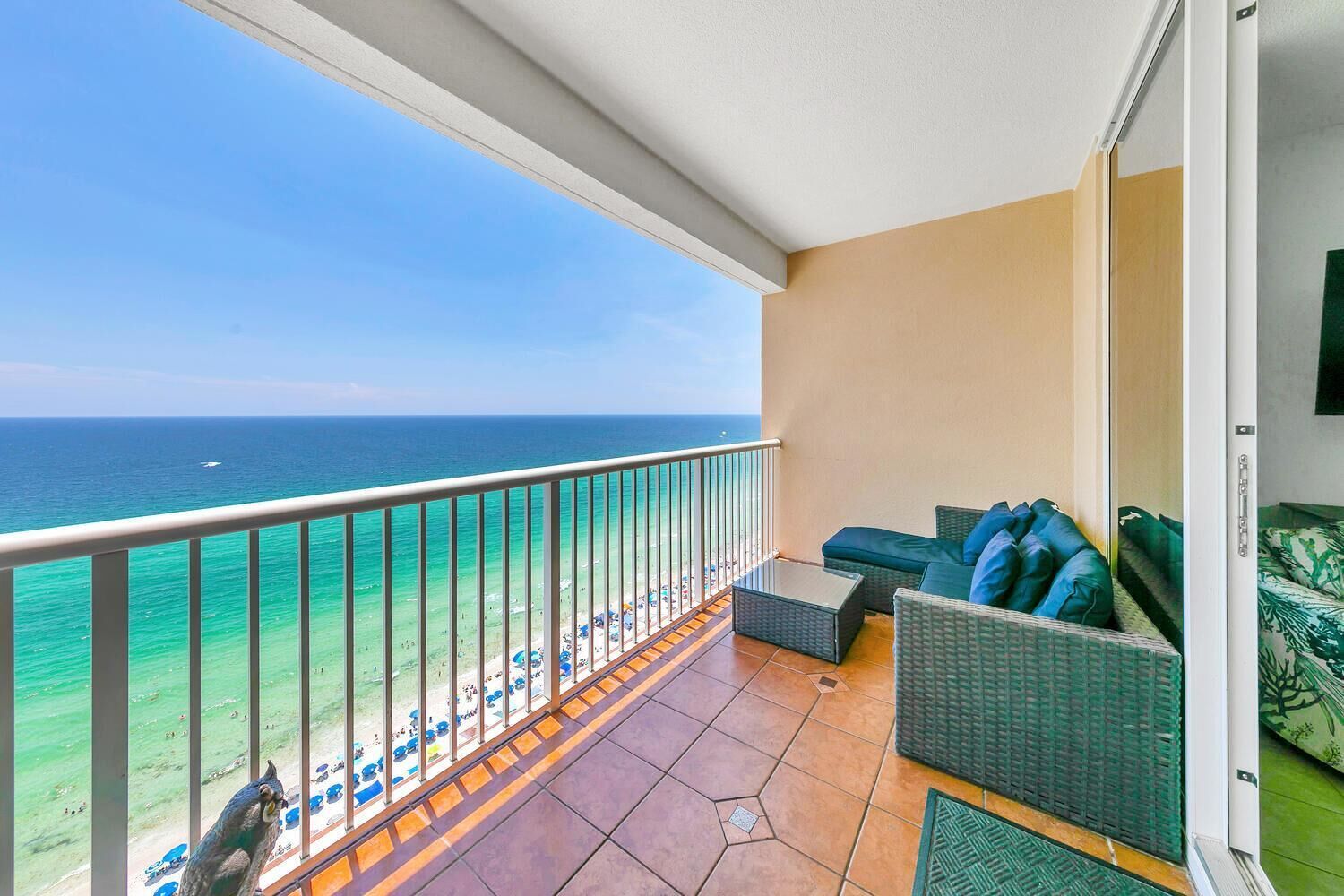 Ein Balkon mit Meerblick, einer Couch und einem kleinen Tisch.