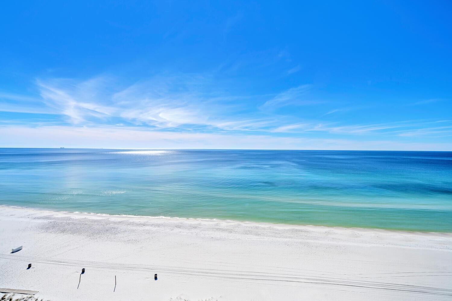 A beach with clear turquoise water and a white sandy shore.