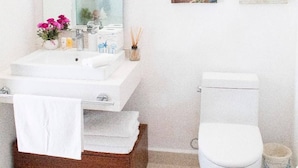 A bathroom with a white sink, mirror, and toilet. There are framed pictures on the wall. - New Villa Deluxe, Golf Club, Punta Cala 205 (Nuevo Nayarit)