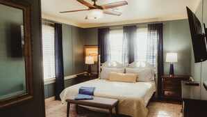 A bedroom with a bed, a ceiling fan, a nightstand with a lamp, and a dresser. - Easy walk to UL, Downtown, Girard park, and multiple music venues. Pet friendly! (Lafayette)
