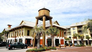 A hotel with a central tower, multiple balconies, and palm trees. - Gulf Place Residences 109 (Santa Rosa Beach)