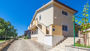 A two-story building with a stone-paved pathway leading to the entrance. - Beautiful apartment in Marcana with WiFi (Marcana)