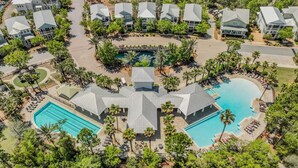A resort with multiple buildings, a central pool, and surrounding greenery.