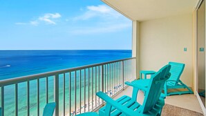 A balcony with turquoise chairs overlooking a beach and the ocean. - Majestic Beach Towers 1-2113 (Panama City Beach)