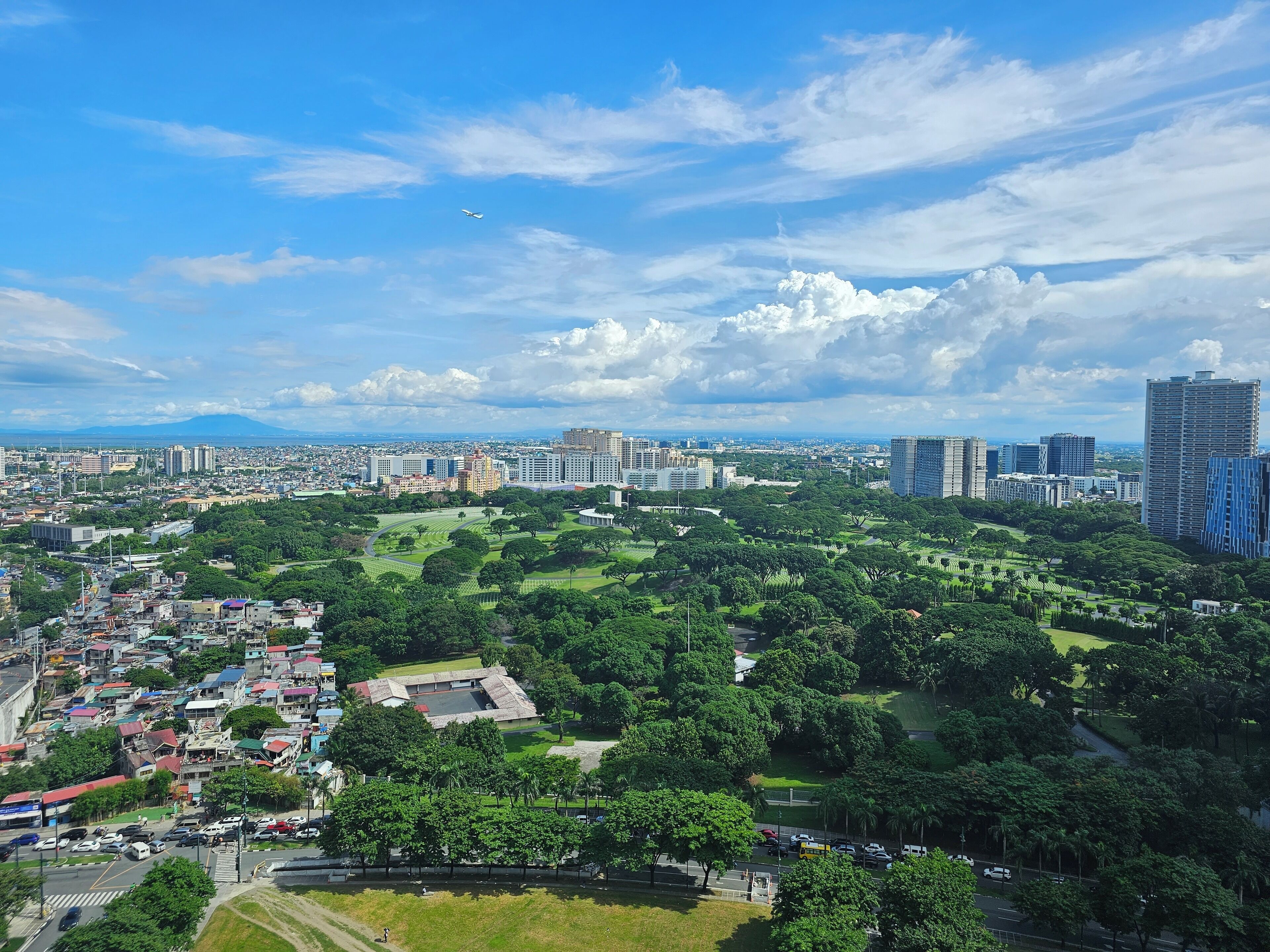 A cityscape with a mix of residential and commercial buildings, a large park, and a stadium.