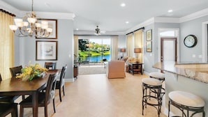 A spacious living area with a dining table, chairs, a sofa, and a bar area. - Ocean Pearl (Destin)